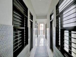Un pasillo de una casa con estantes de madera y ventanas. en Hotel O Hotel Valentine's, en Rohtak