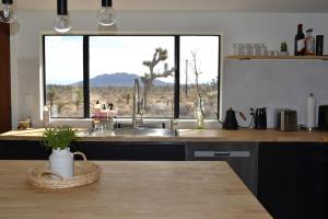a kitchen with a sink and a large window at Casa Nova Romantic Desert Escape in Yucca Valley