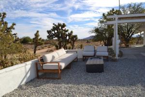 a group of chairs and a couch on a patio at Casa Nova Romantic Desert Escape in Yucca Valley