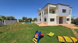 a house with a yard with chairs and a pool at إقامة السبيل in Fès