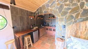 a kitchen with a stone wall at Cabaña Magica Estilo Hobbit in Machetá
