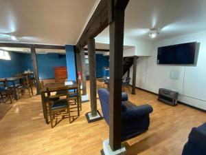 a living room with a tv and a table and chairs at Apart Newen Osorno in Osorno