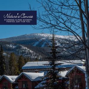 a snow covered mountain in the distance with a building at Hygge Hideaway in Winter Park