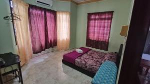 a bedroom with a bed in a room with windows at Homestay Segamat - Teratak Impian in Segamat