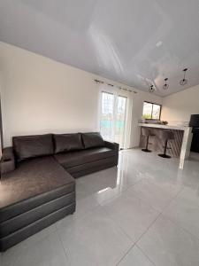 a living room with a couch and a kitchen at The Slothie's House in Tapantí