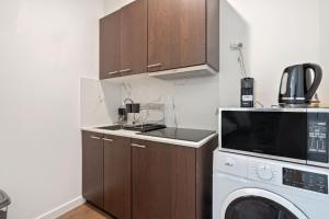 una cucina con lavatrice e microonde di Cozy Kambah 1 Bedroom Near Shops & Parks a Kambah