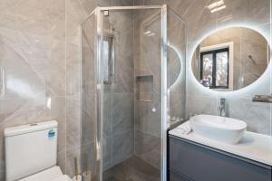 un bagno con un water, un lavandino e uno specchio di Cozy Kambah 1 Bedroom Near Shops & Parks a Kambah