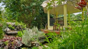 a garden with a gazebo in the middle at Nature's Hideaway Homestay in Ban Lam Thong Lang +9 photos