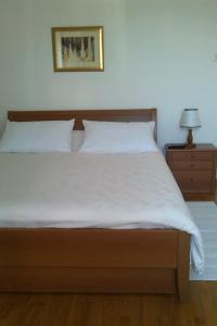 a bedroom with a large bed with white sheets and a lamp at Rooms with WiFi Korcula - 24232 in Korčula