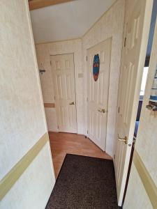 an empty room with two doors and a rug at Sea View Escape 2 Bedroom Pet Friendly Caravan at Clarach Bay Gm3 in Aberystwyth +18 photos