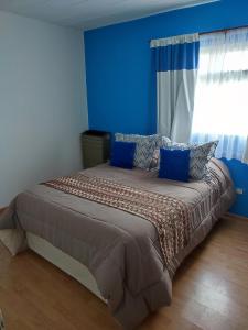 a blue bedroom with a large bed with blue walls at Mil5inco Al Lago in El Calafate +12 photos
