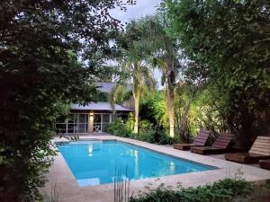 a swimming pool in a yard with trees at La Ignacia Bed and Breakfast in Pilar