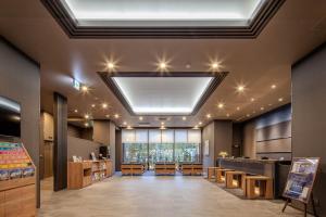 a large room with a restaurant with a ceiling with lights at Hotel Route Inn Okayama Ibara in Ibara