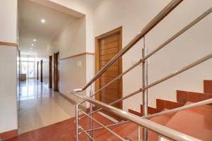 a staircase in a house with wooden doors at Hotel O The Gomti Hotel in Dehradun
