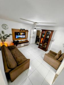 a living room with two couches and a flat screen tv at Cobertura em Caiobá-Matinhos-Pr 2 quadras do mar in Matinhos