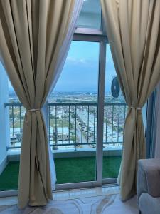 two curtains in a room with a view of the city at Sky9Haven Homestay in Ipoh