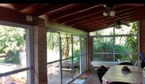 a screened in porch with a table and windows at La Ignacia Bed and Breakfast in Pilar