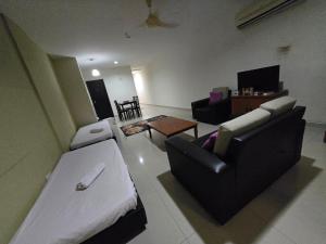 a living room with a couch and a chair at Okay Marina Lumut Homestay in Lumut
