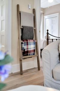 a room with a chair with blankets and a bed at Le Wapiti - 75 Butternut in Cherry Valley