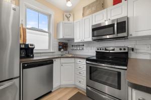 a kitchen with stainless steel appliances and white cabinets at Le Wapiti - 75 Butternut in Cherry Valley