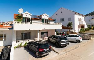 Deux voitures garées sur un parking en face d'une maison dans l'établissement 2 Bedroom Lovely Apartment In Hvar, à Hvar