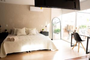 麦德林New Apt w private Jacuzzi & AC的一间卧室配有一张床铺和一张桌子,并设有一个阳台