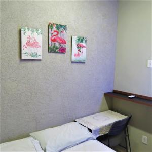 une pièce avec quatre photos de flamants roses sur le mur dans l'établissement Hostel ElianeMS, à Campo Grande 29 autres photos