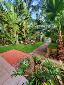 a garden with palm trees and a pathway at Marangu Serenity Homes in Marangu