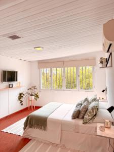 a white bedroom with a large bed and windows at Ubicación Vista Cochera Wifi full in Mendoza