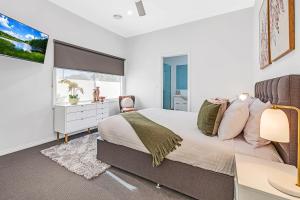 a bedroom with a large bed and a window at Kabinga Kottage - Echuca Holiday Homes in Moama +15 photos