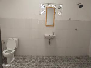 a bathroom with a toilet and a sink at Losmen katiet beach front, lances right surf camp peter Homestay in Katiet