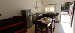 a small kitchen with a table and a refrigerator at Las Costas - Tu descanso in Cañuelas