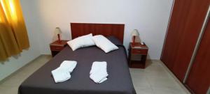 a bedroom with a bed with two white towels on it at Las Costas - Tu descanso in Cañuelas