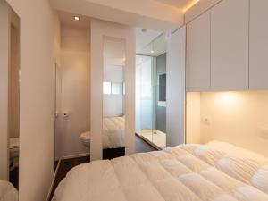 a bedroom with a white bed and a bathroom at Studio in Ostend near Beach and Promenade in Ostend