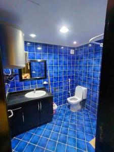 a blue tiled bathroom with a toilet and a sink at Porto matrouh Blue sea in Marsa Matruh