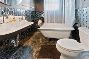 a bathroom with a toilet and a sink and a tub at Stylish NEW Home -6 Beds- Near DT & PHX Airport in Phoenix +30 photos