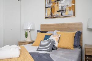 ein Bett mit blauen und gelben Kissen darauf in der Unterkunft Luxury New Penthouse Roof Balcony Washer Dryer B406 in Atlanta