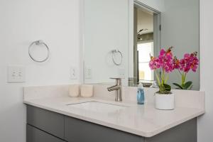 ein weißes Badezimmer mit Waschbecken und Spiegel in der Unterkunft Luxury New Penthouse Roof Balcony Washer Dryer B406 in Atlanta