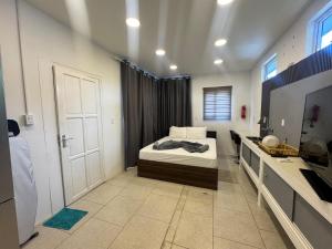 a bedroom with a bed and a bathroom with a sink at Colony Stay in Paramaribo