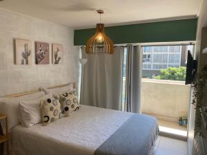 Un dormitorio con una cama y una ventana grande. en Lindo departamento tipo Loft en Ñuñoa, en Santiago