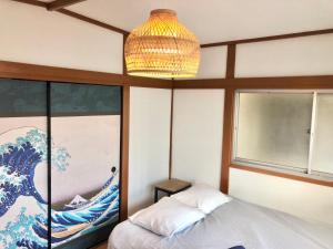 a bedroom with a chandelier and a painting on the wall at HOKUSAI-KAN Osaka Taisho in Osaka