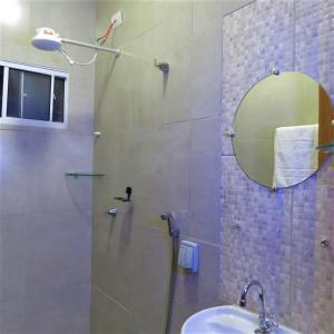 a bathroom with a shower with a sink and a mirror at Hostel ElianeMS Quartos Privativos com Banheiro in Campo Grande +29 photos