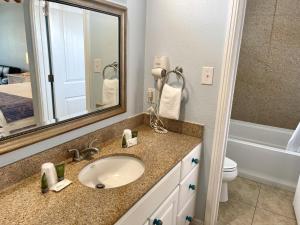 a bathroom with a sink and a mirror and a toilet at Beachgate Condo Suites and Hotel 437 condo in Port Aransas