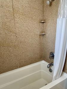 a bathroom with a bath tub with a shower curtain at Beachgate Condo Suites and Hotel 437 condo in Port Aransas
