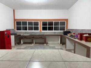 a kitchen with a table and a red refrigerator at Hotel La C in San José Iturbide