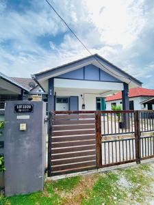 a house with a gate and a fence at Tok Jiring Boutique Homestay in Kuala Terengganu