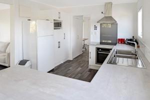 a white kitchen with a sink and a refrigerator at Mackenzie Batch in Twizel