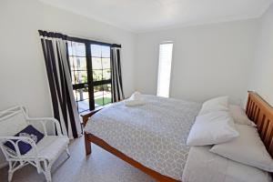 a bedroom with a bed and a chair and a window at Mackenzie Batch in Twizel
