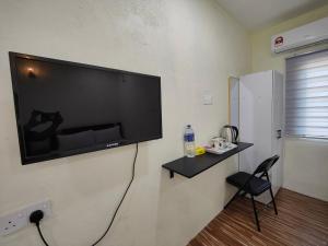 een flatscreen-tv aan een muur in een kamer bij Reds Roomstay Pantai Penarik 4 in Pulau Che Selamah