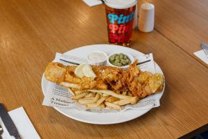 a plate of fish and french fries and a drink at Holiday Inn Express Aberdeen Airport by IHG in Dyce
